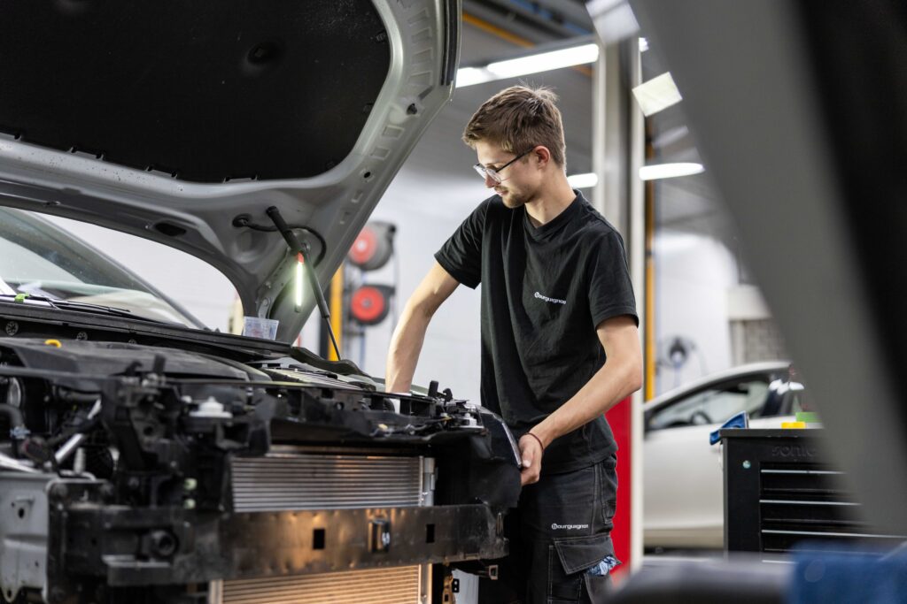 Medewerker sleutelt aan auto