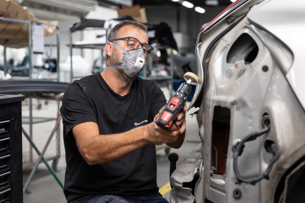 Medewerker herstelt schade aan auto